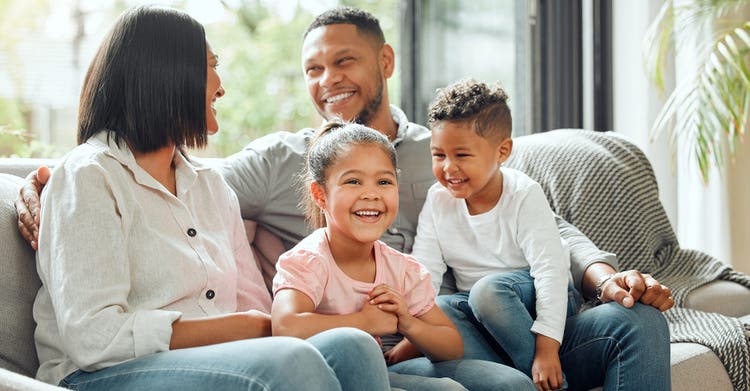 Family with children sitting on lounge chair smiling