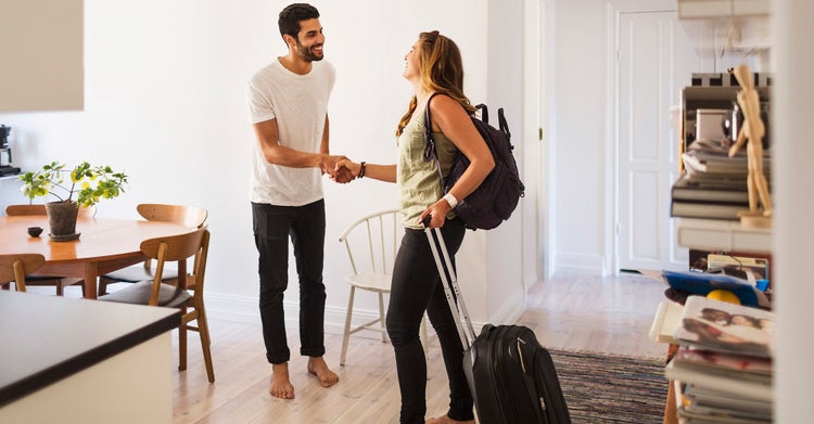 Young woman and man shaking hands in an apartment