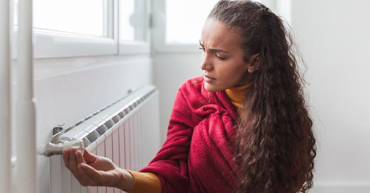 Woman looking concerned about the heating appliance in her home